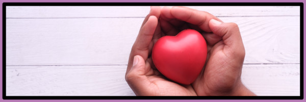 Hands holding a heart symbolising charitable giving and donations.